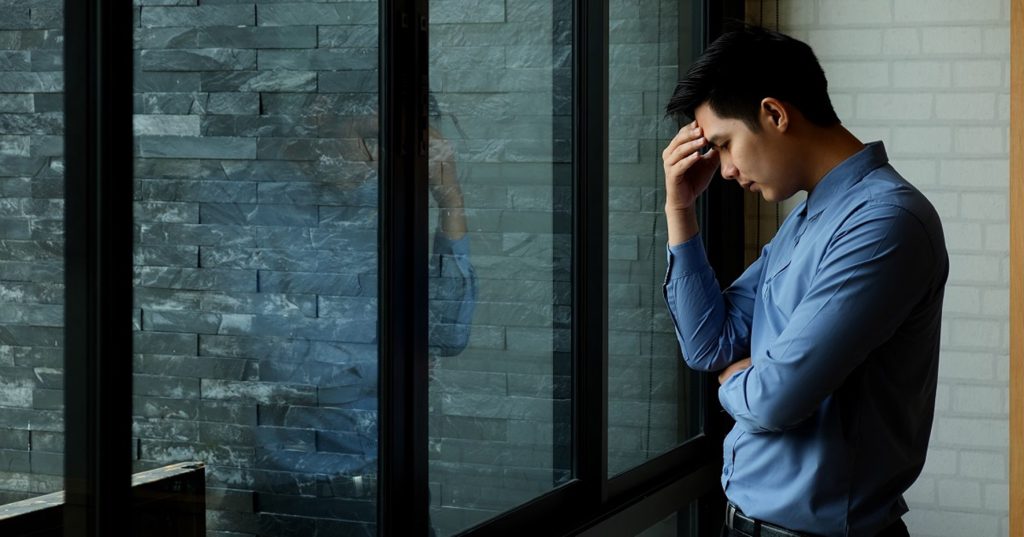 成果主義の導入がうまくいかず悩んでいる男性ビジネスパーソン