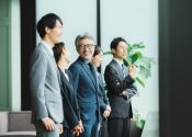 転職後、即戦力および組織のトップとしてチームを牽引する50代の男性ビジネスパーソンとチームメンバー